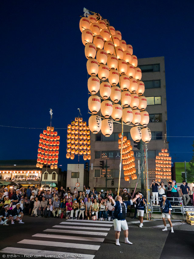 Teilnehmer des Akita Kanto Festivals balanciert Stab mit Papierlaternen