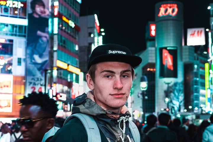 Als Deutscher neu in Japan – erste Eindrücke im Alltag Junger Deutscher steht nachts in einer belebten japanischen Großstadt mit Neonlichtern und Menschenmengen – Symbol für Kulturschock und Alltag nach der Auswanderung nach Japan