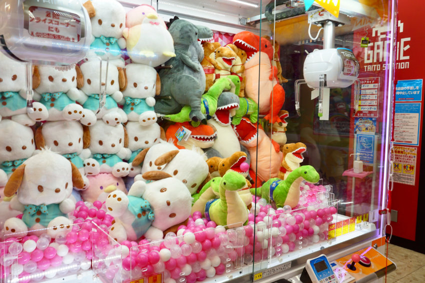 Greifmaschine mit Plüschtieren in einem japanischen Arcade Center mit TAITO Station Automaten