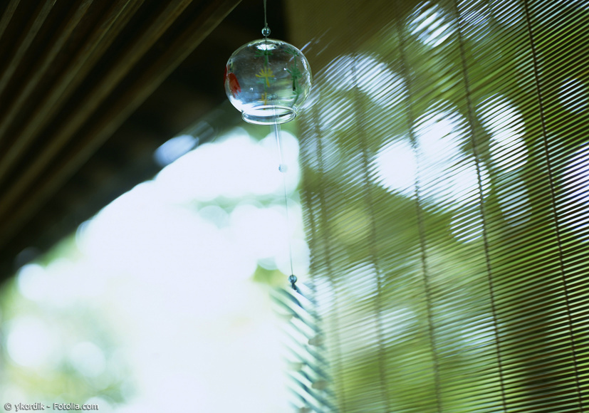 Japanisches Glas-Windspiel vor Bambusrollo und Sommertag