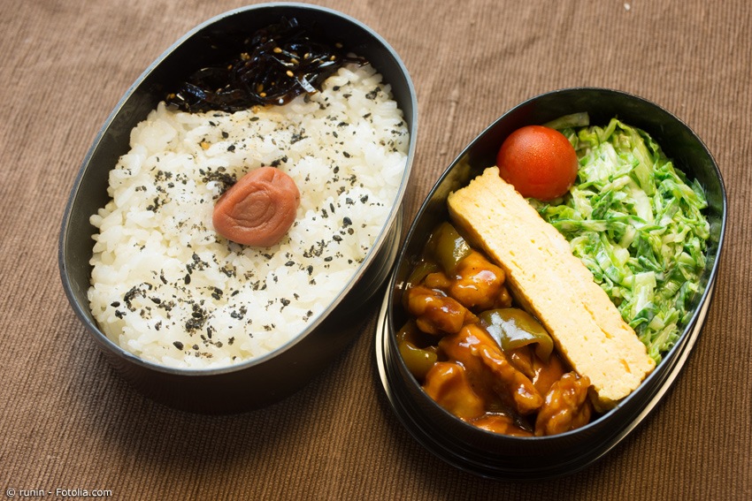 Bento mit Reis, Umeboshi, Salat, Ei und Schweine-Curry