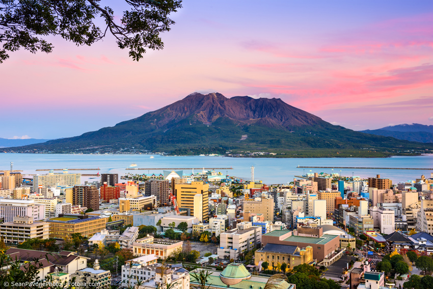 Der Vulkan Sakurajima im Abendlicht mit Stadtkulisse