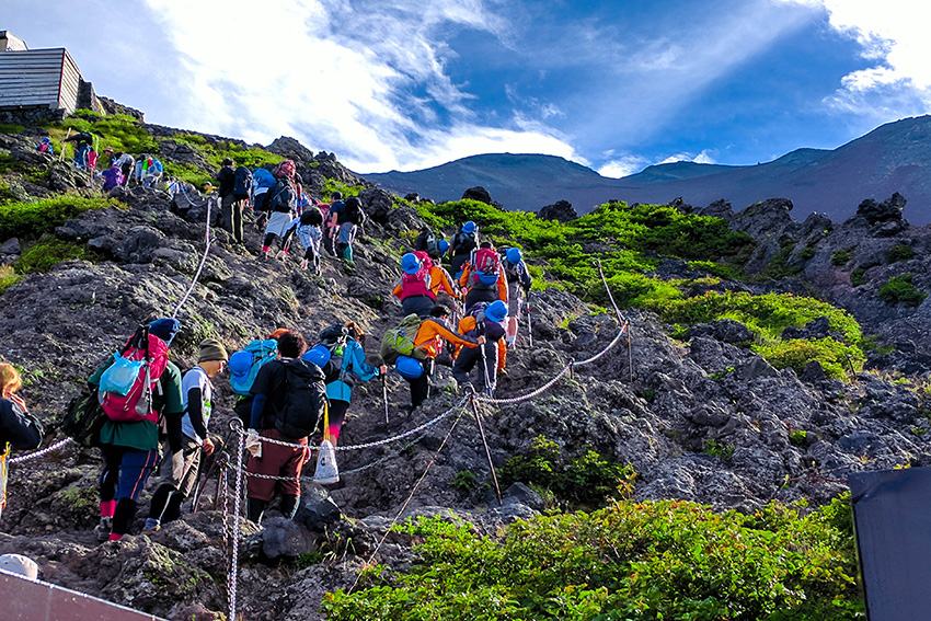 Pilger erklimmen den heiligen Berg Fuji in Japan Gruppe von Pilgern klettert über einen felsigen Pfad den heiligen Berg Fuji in Japan hinauf