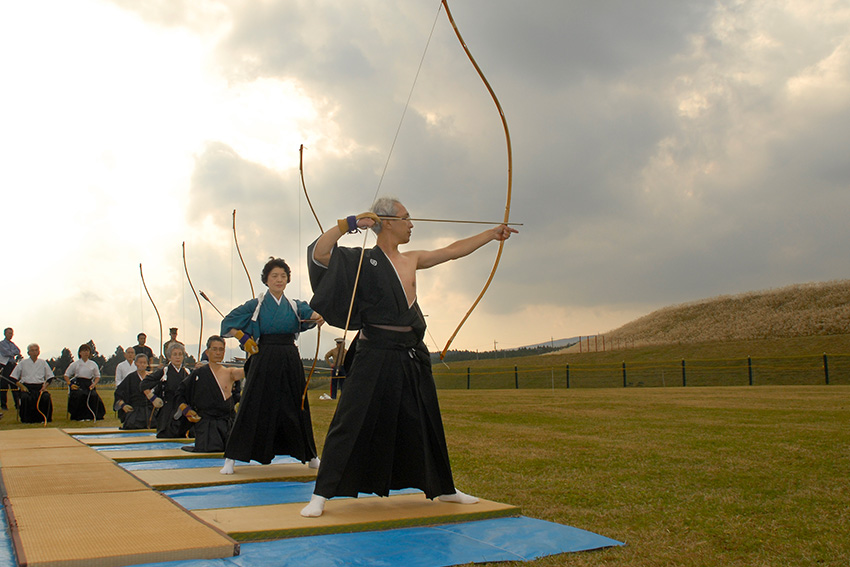 Kyūdō-Schützen in traditioneller Kleidung mit Hakama beim japanischen Bogenschießen im Freien