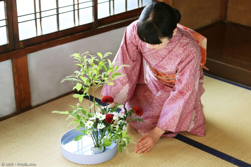 Ikebana Blumensteckkunst mit Japanerin im Kimono