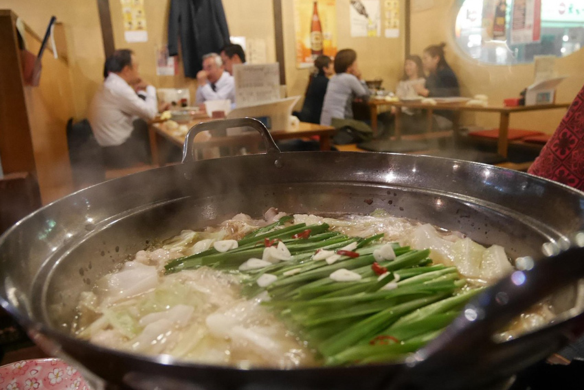 Japanisches Abendessen in einem Izakaya mit dampfendem Nabe-Hotpot