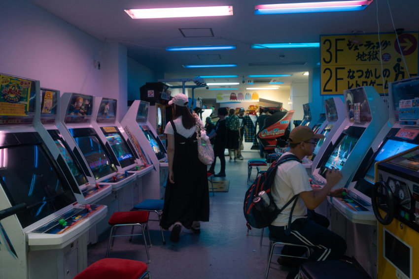 Innenansicht eines japanischen Arcade Centers mit klassischen Spielautoma-ten und Besuchern
