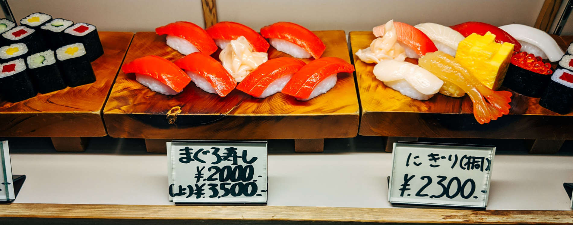 Essen bestellen in Japan: Speisenmodelle als Orientierungshilfe Sushi-Speisenmodelle mit japanischen Preisschildern im Schaufenster eines Restaurants als Hilfe beim Essen bestellen ohne Japanisch