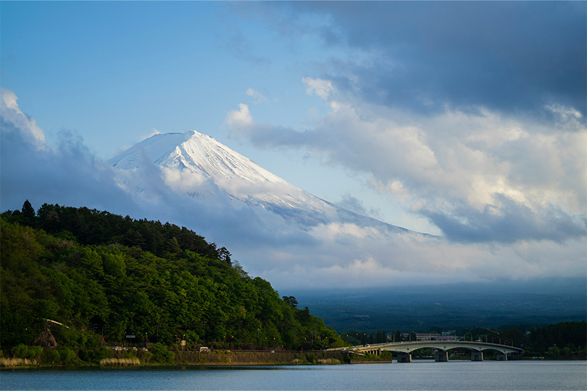Blick auf den schneebedeckten Mount Fuji hinter einem See im Fuji-Hakone-Izu Nationalpark
