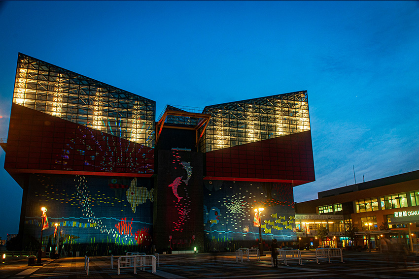Osaka Aquarium Kaiyukan: ikonische Architektur am Hafen Außenansicht des Osaka Aquarium Kaiyukan am Abend mit markanter Glasarchitektur und farbig beleuchteter Fassade