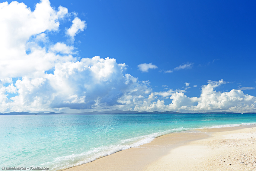 Sandstrand und blaues Meer auf Okinawa im Sommer