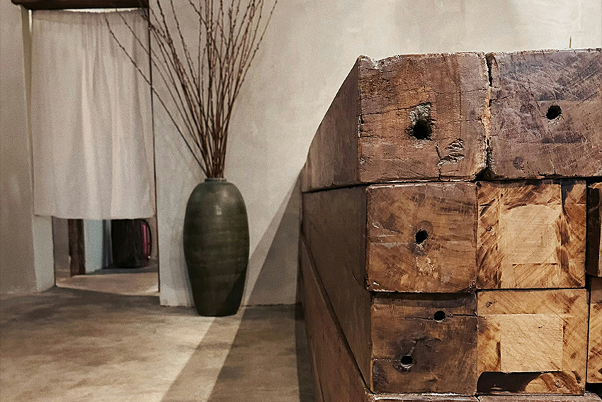 Wabi-Sabi Interieur mit gealtertem Holz, Keramikvase und reduzierter Raumgestaltung