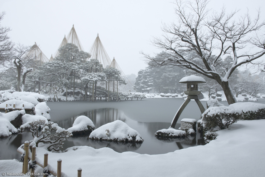 Kenrokuen im Winter mit zugefrorenem Teich und Laterne