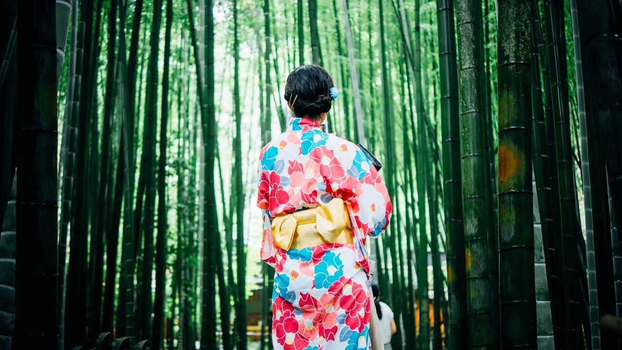 Asiatische Frau im Kimono im Bambuswald