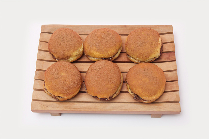 Sechs Dorayaki mit Anko Füllung auf einem Holztablett angerichtet