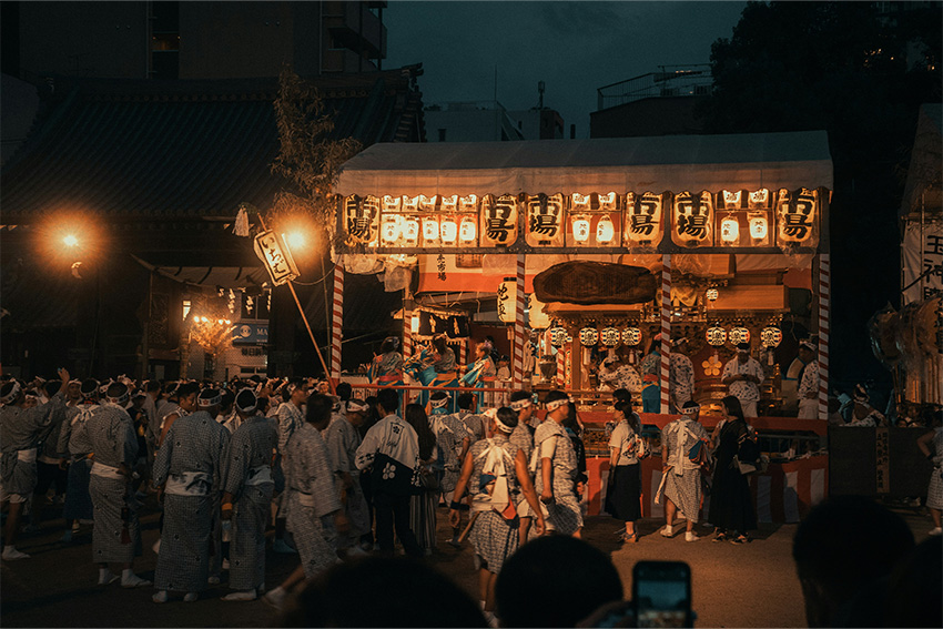 Tenjin Matsuri – traditionelles Sommerfest in Osaka Abendliche Szene vom Tenjin Matsuri in Osaka mit festlich gekleideten Teilnehmern, beleuchteten Laternen und traditionellem Festwagen