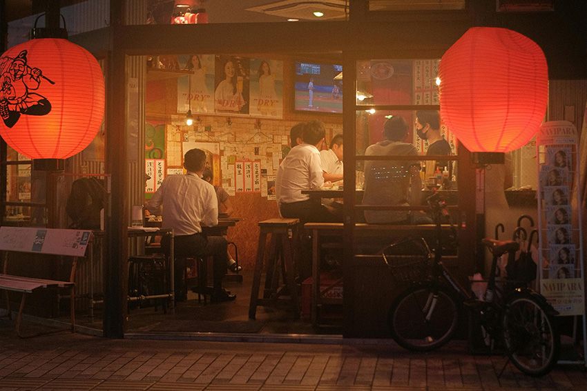 Salarymen beim After-Work-Treffen im Izakaya Salarymen beim Nomikai in einem japanischen Izakaya nach Feierabend