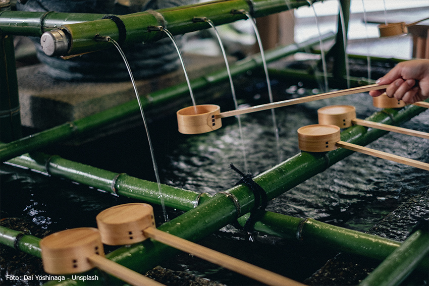 Rituelle Reinigung am Temizuya eines Shintō-Schreins Holzkellen liegen auf einem Bambus-Wasserbecken an einem japanischen Schrein, mit denen Besucher Hände und Mund reinigen