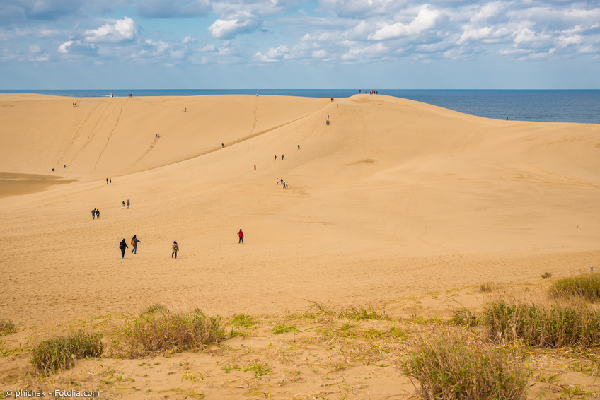 Große Sanddünen mit Wanderern vor dem Japanischen Meer