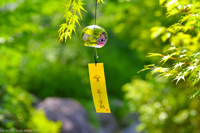 Windspiel aus Glas an einem japanischen Ahornzweig im Sommer